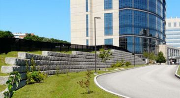 A large building with a lot of windows is sitting next to a road.