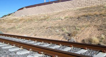 A train track with a brick wall in the background.
