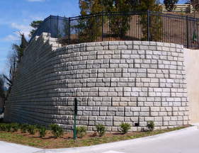 A large brick wall with a fence in the background