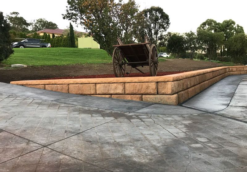A wheelbarrow is sitting on top of a concrete wall.