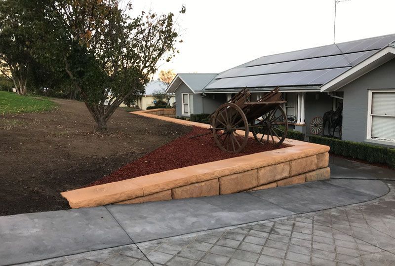 A horse drawn carriage is parked in front of a house with solar panels on the roof.