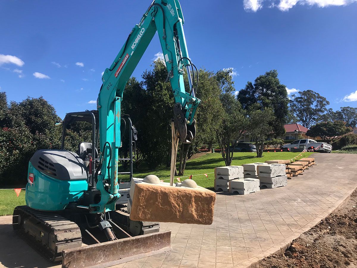 A blue excavator is digging a hole in the ground.
