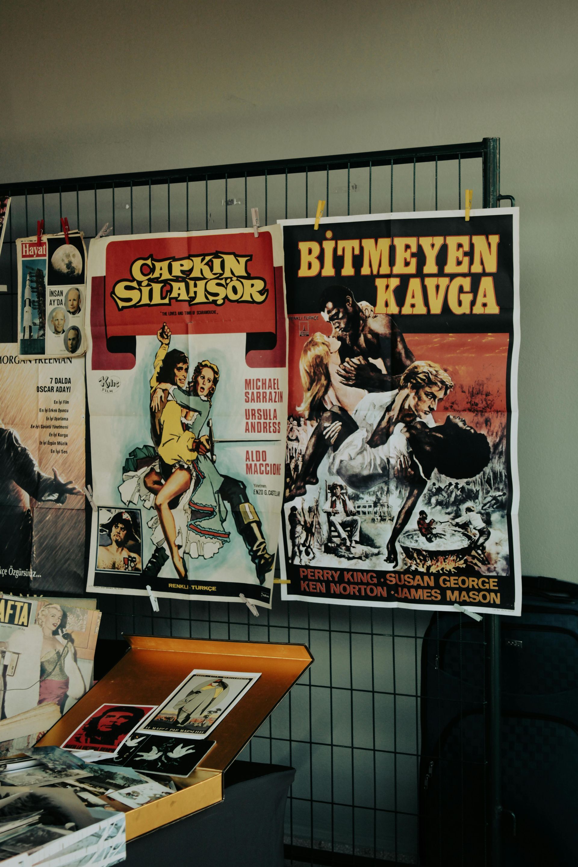 Movie posters on a display. The posters, in Turkish, feature illustrations of action scenes in vibrant colors.