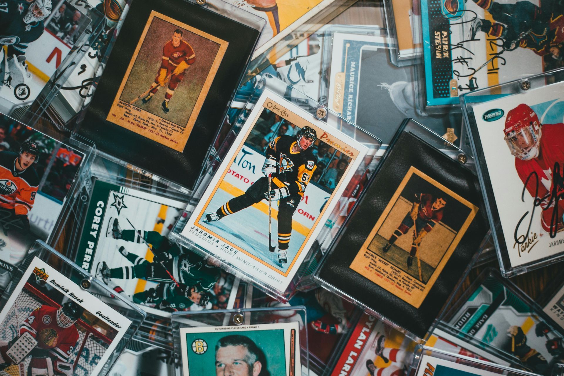 Pile of hockey trading cards, some in protective cases, various colors.