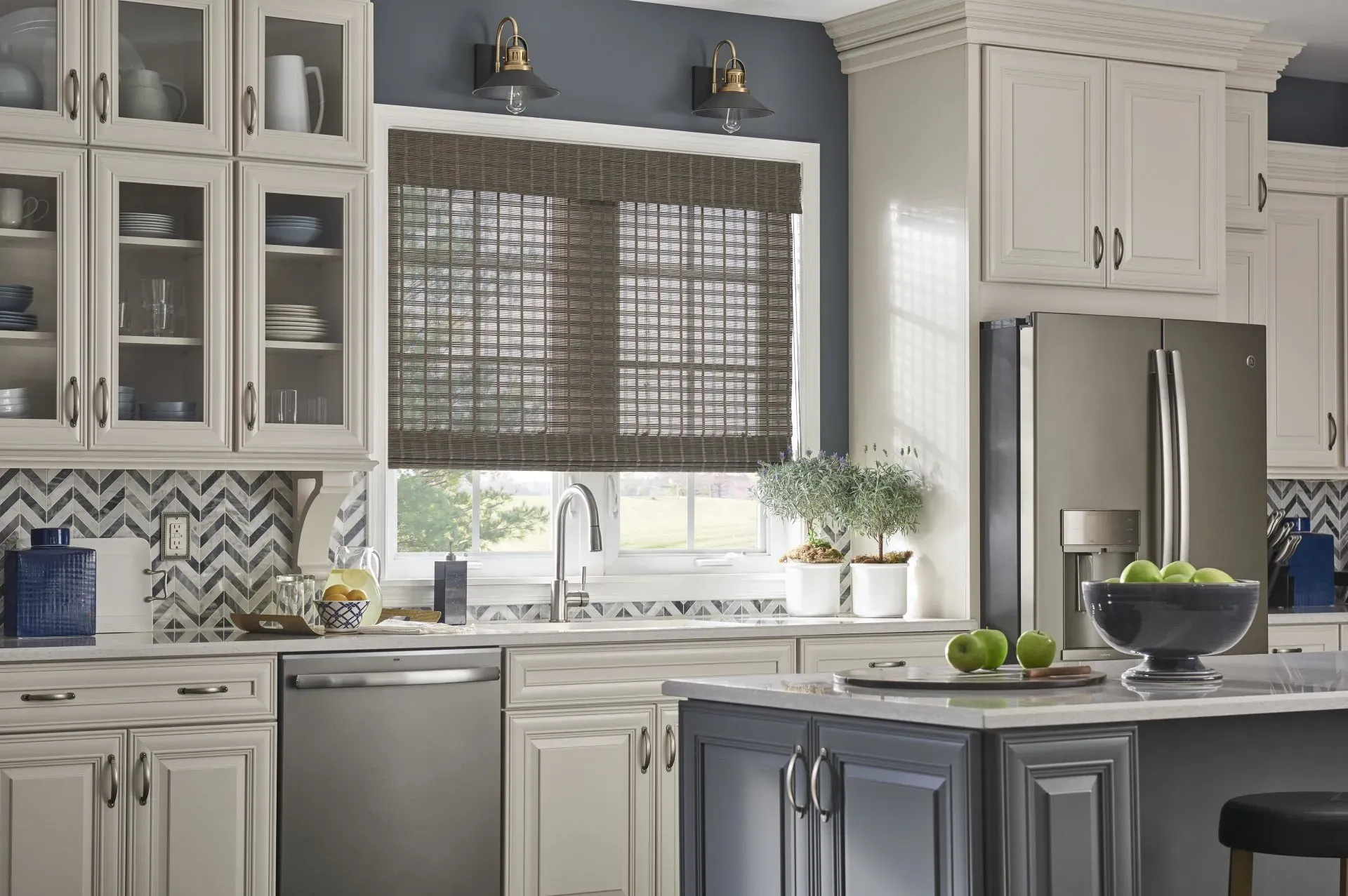 A kitchen with white cabinets , stainless steel appliances, and woven wood shades on the windows.