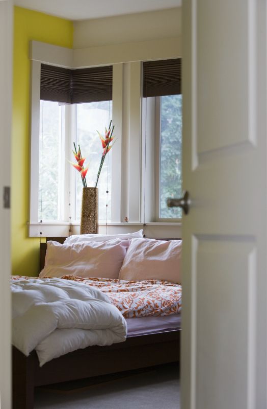 a bedroom with a bed , window , and yellow walls honeycomb shades bedroom Georgia.