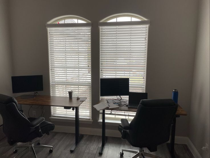 a room with two desks and two chairs and two windows with blinds window treatment solutions Love is Blinds
