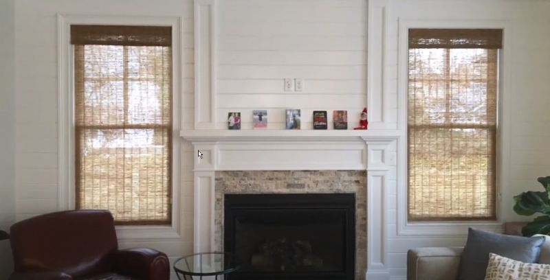 a living room with a fireplace and two windows Edge binding woven wood shades Georgia.