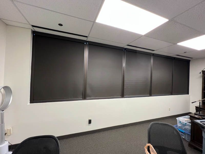 A room with a lot of windows with window treatments and a fan on the ceiling. Love is Blinds