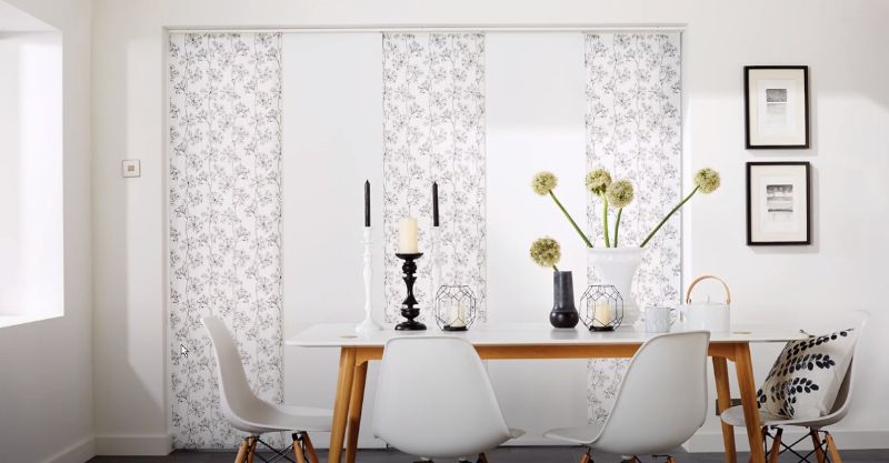 a dining room with a table and chairs and sliding panels on the wall Versatile room solutions patterned panel track shades Georgia.