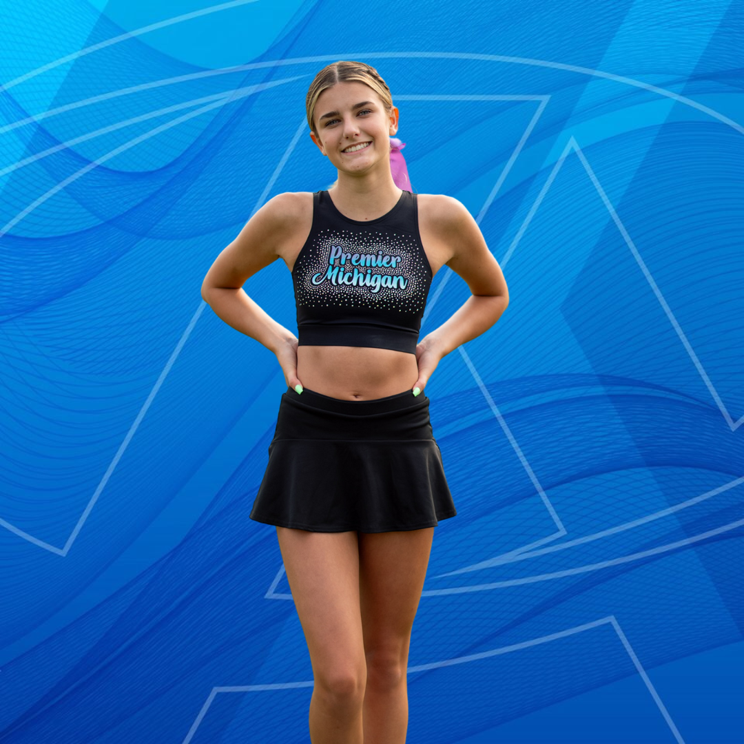 A little girl with a bow in her hair is smiling in front of a blue letter r