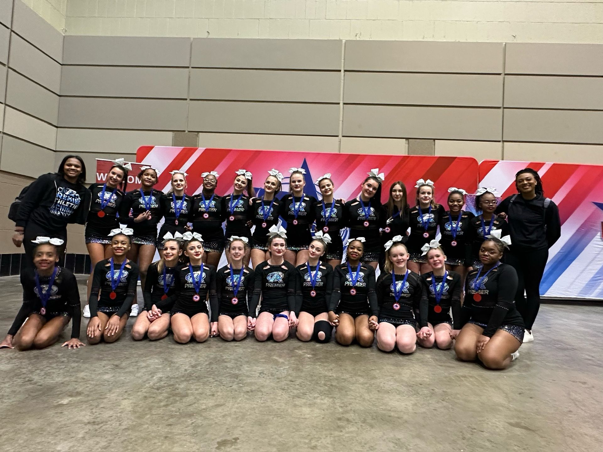 A group of cheerleaders are performing in front of a large letter m.