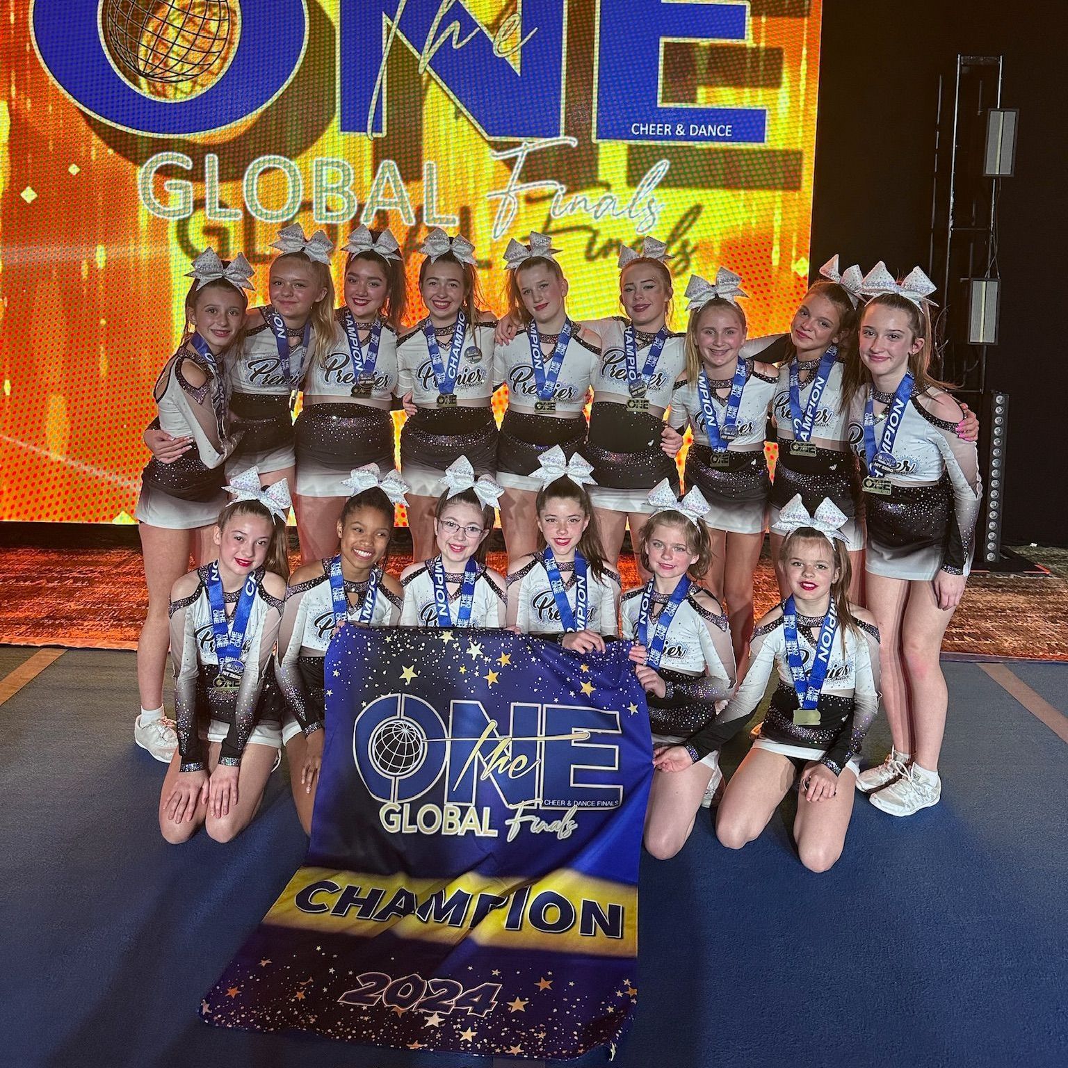 A group of cheerleaders are posing for a picture with a banner that says 1st place