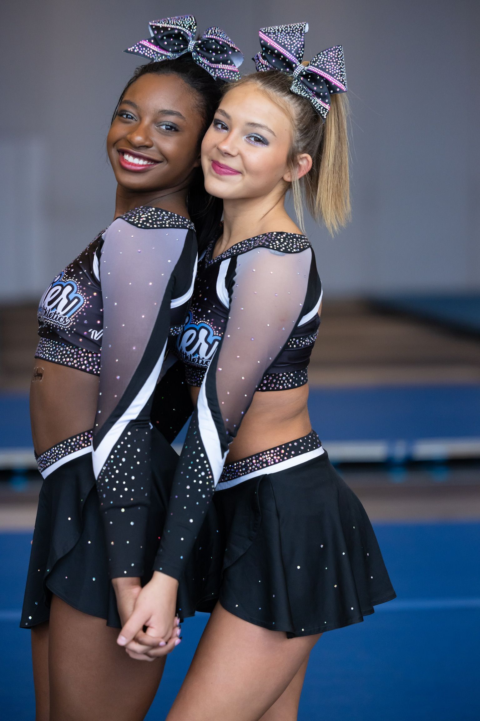 A cheerleader wearing a premier shirt makes a heart shape with her hands