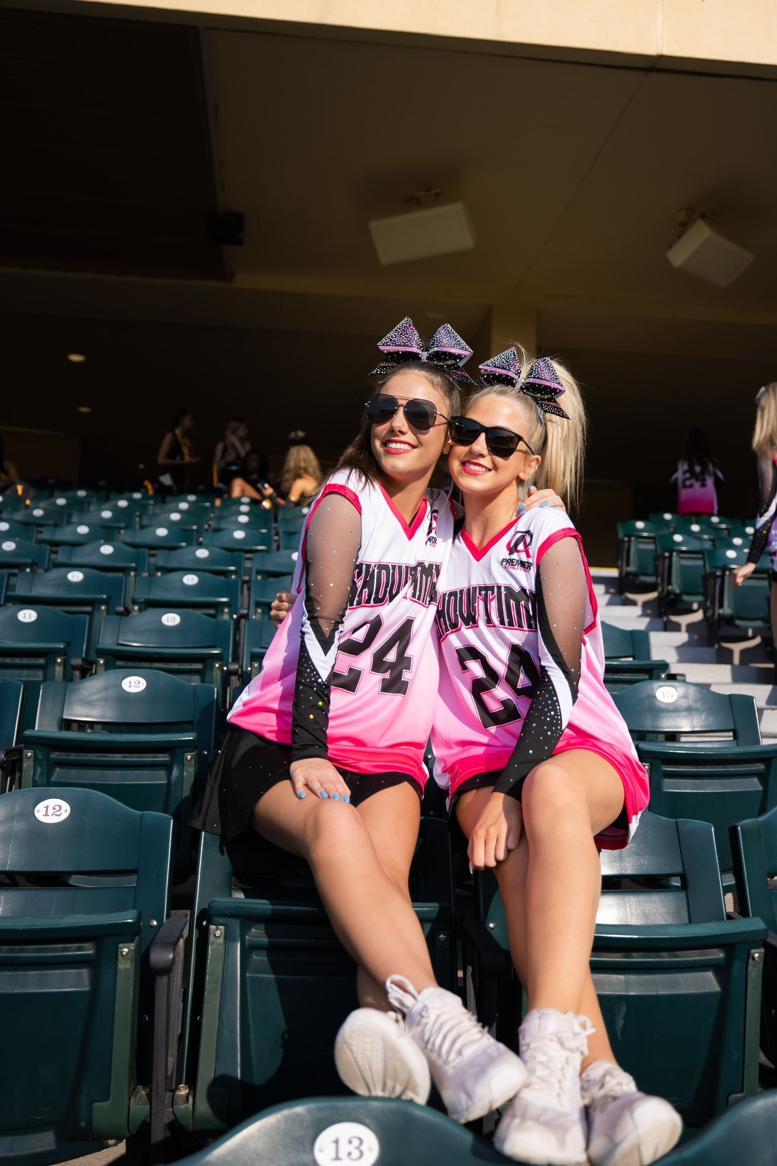 Two cheerleaders wearing premier uniforms are posing for a picture