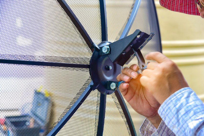 Person Installing A Satellite Dish — Aliance Group in Macksville, NSW
