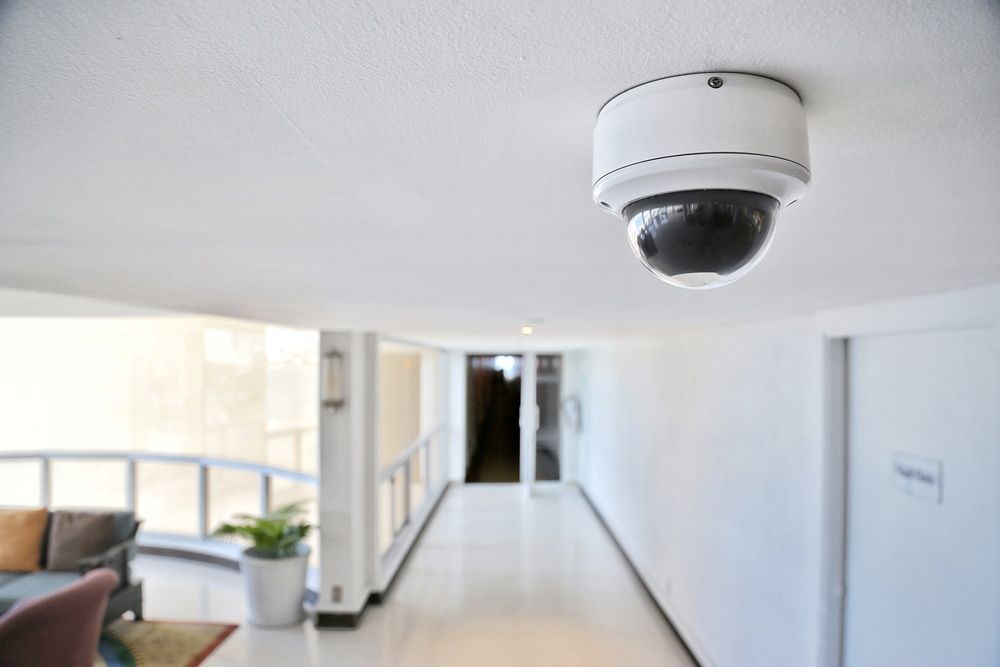 Security Camera Mounted On A White Ceiling, Overlooking An Interior Hallway — Aliance Group in Bonville, NSW