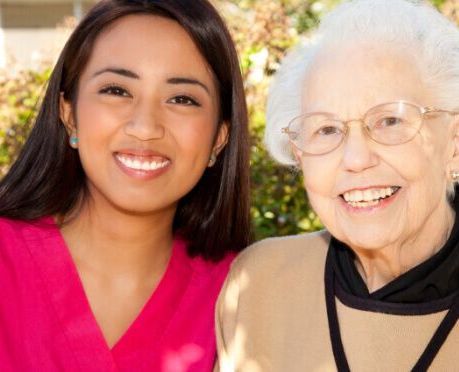 A young woman and an older woman are smiling for the camera.