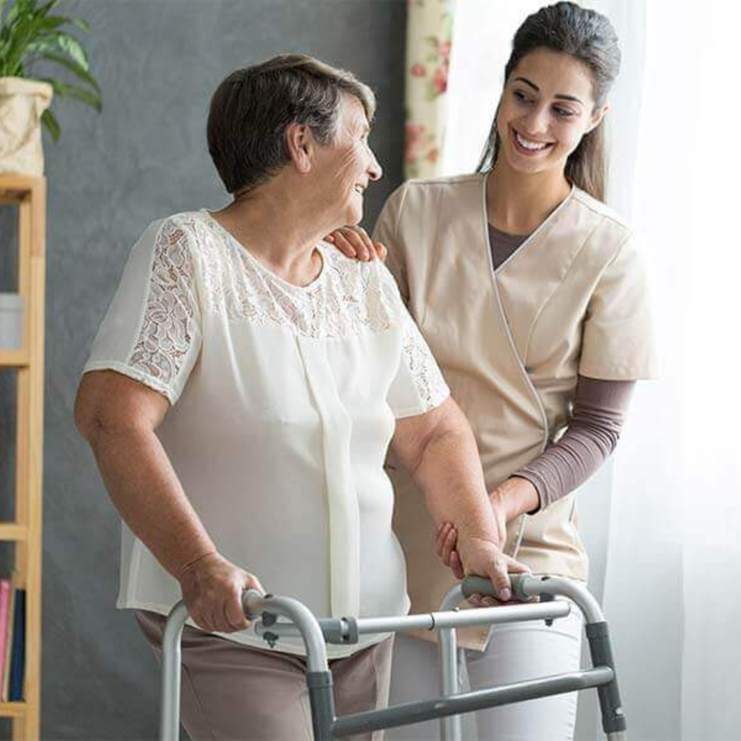 A woman is helping an older woman use a walker.