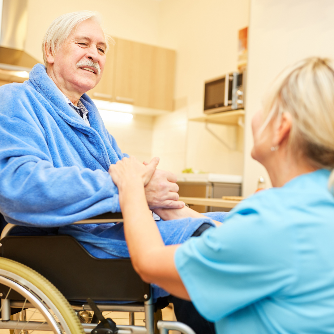 A man in a wheelchair is talking to a nurse