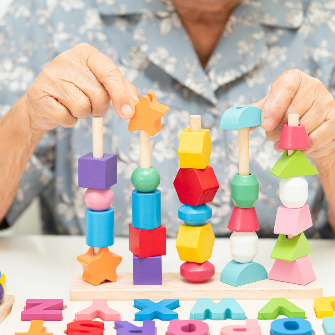 A woman is playing with a colorful stacking toy