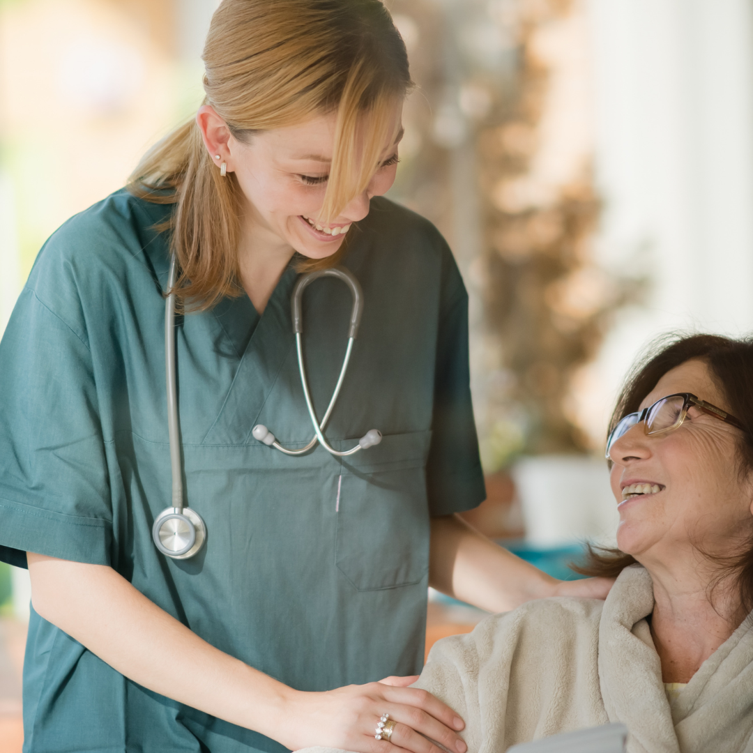 A nurse with a stethoscope is talking to an elderly woman