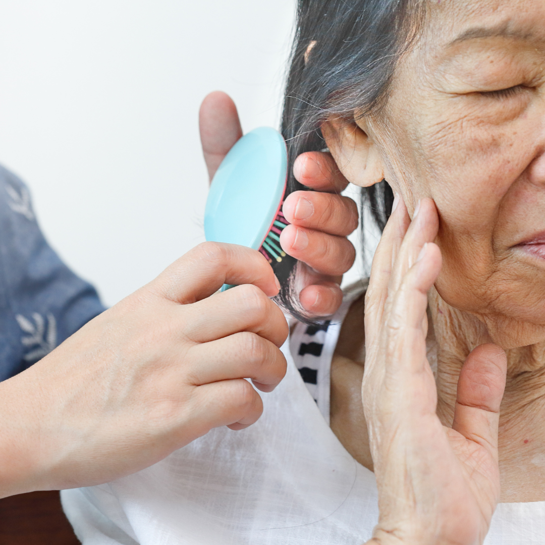 An older woman is getting her hair done by a younger woman