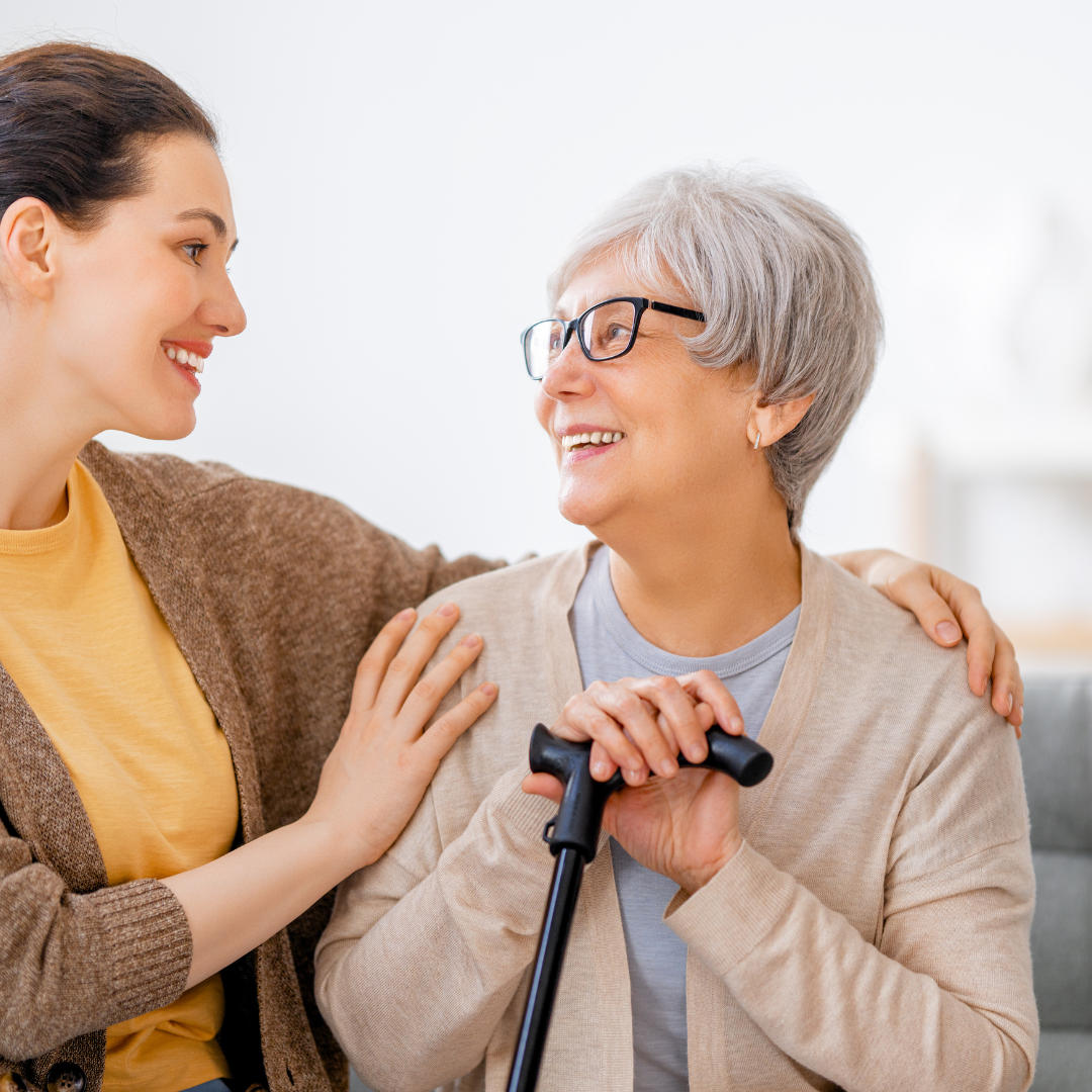 A young woman is talking to an older woman with a cane.