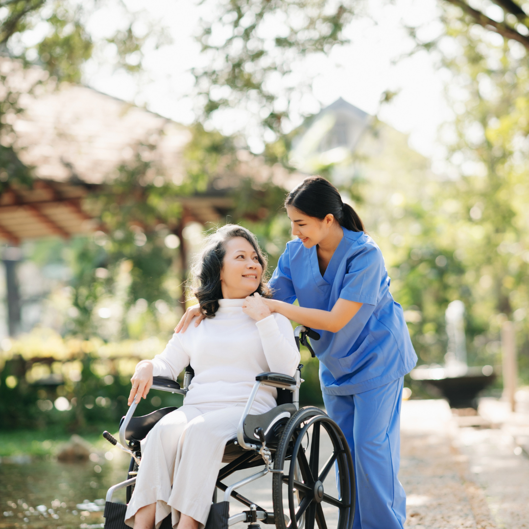 A woman in a wheelchair is being helped by a nurse