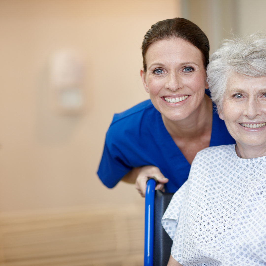 A nurse pushes an elderly woman in a wheelchair