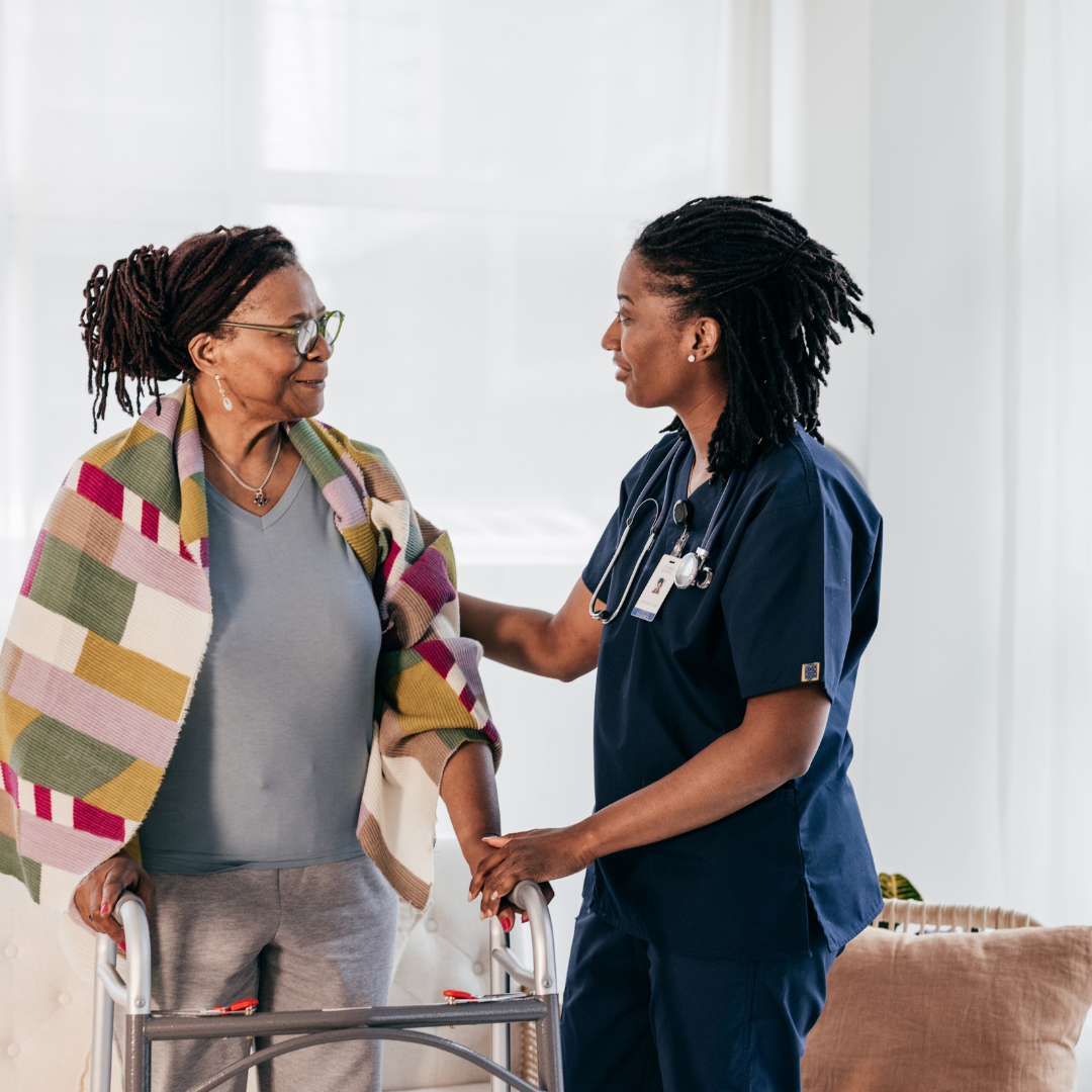 A nurse is helping an elderly woman with a walker.