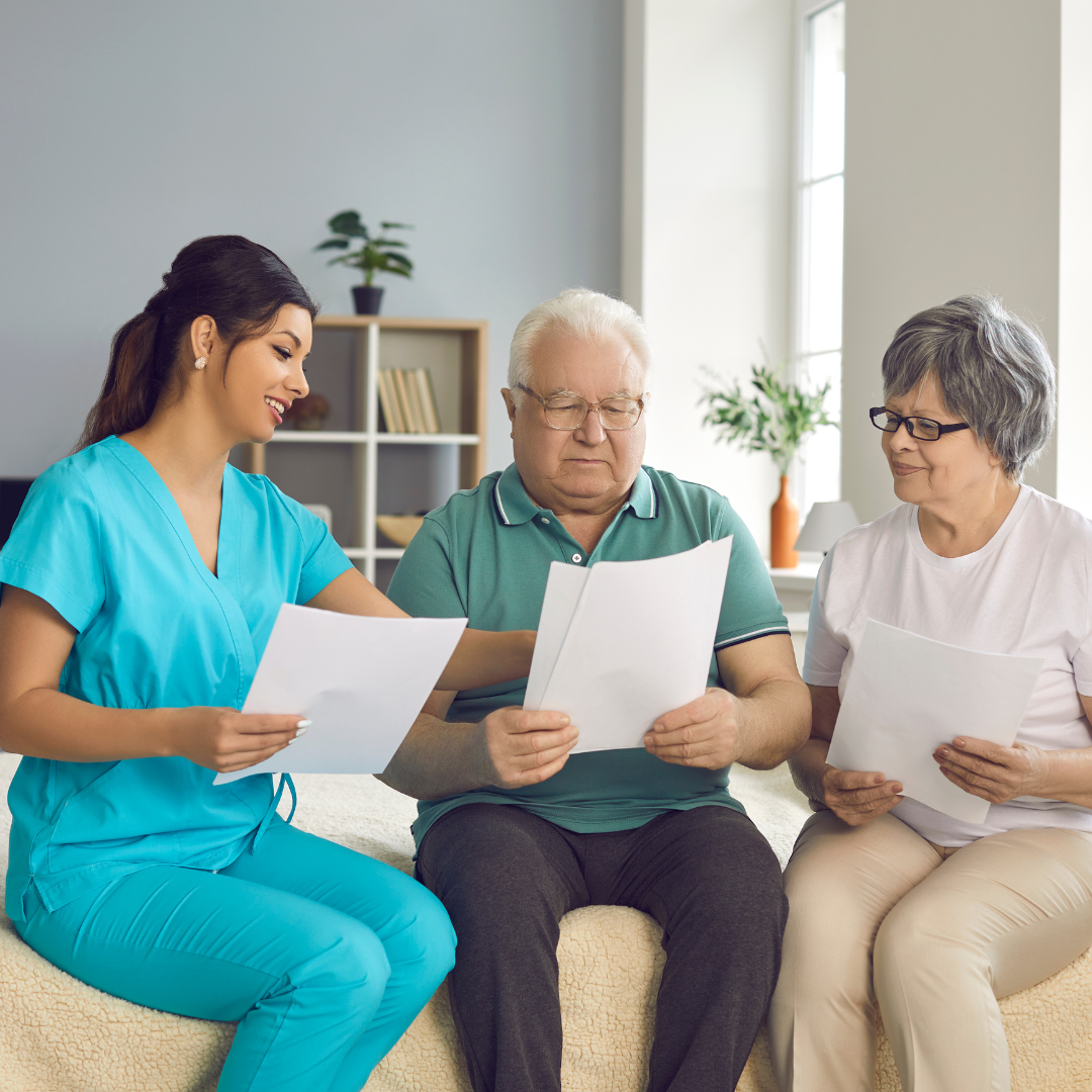 A group of people are sitting on a couch looking at papers.