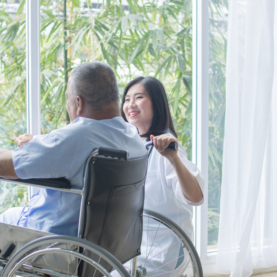 A woman is helping a man in a wheelchair.