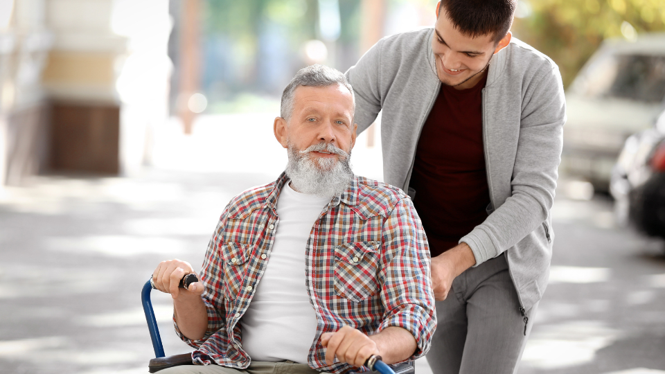 Young Caregiver Walking with Senior Man