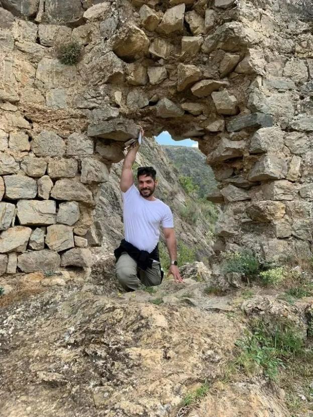 A Man Is Kneeling Down in Front of A Stone Wall — Action Physiotherapy in Cooks Hill, NSW