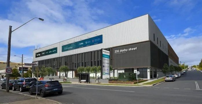 A Large Building Is Sitting on The Corner of A City Street — Action Physiotherapy in Cooks Hill, NSW