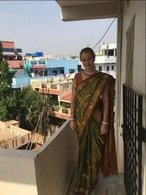A Woman in A Saree Is Standing on A Balcony — Action Physiotherapy in Cooks Hill, NSW