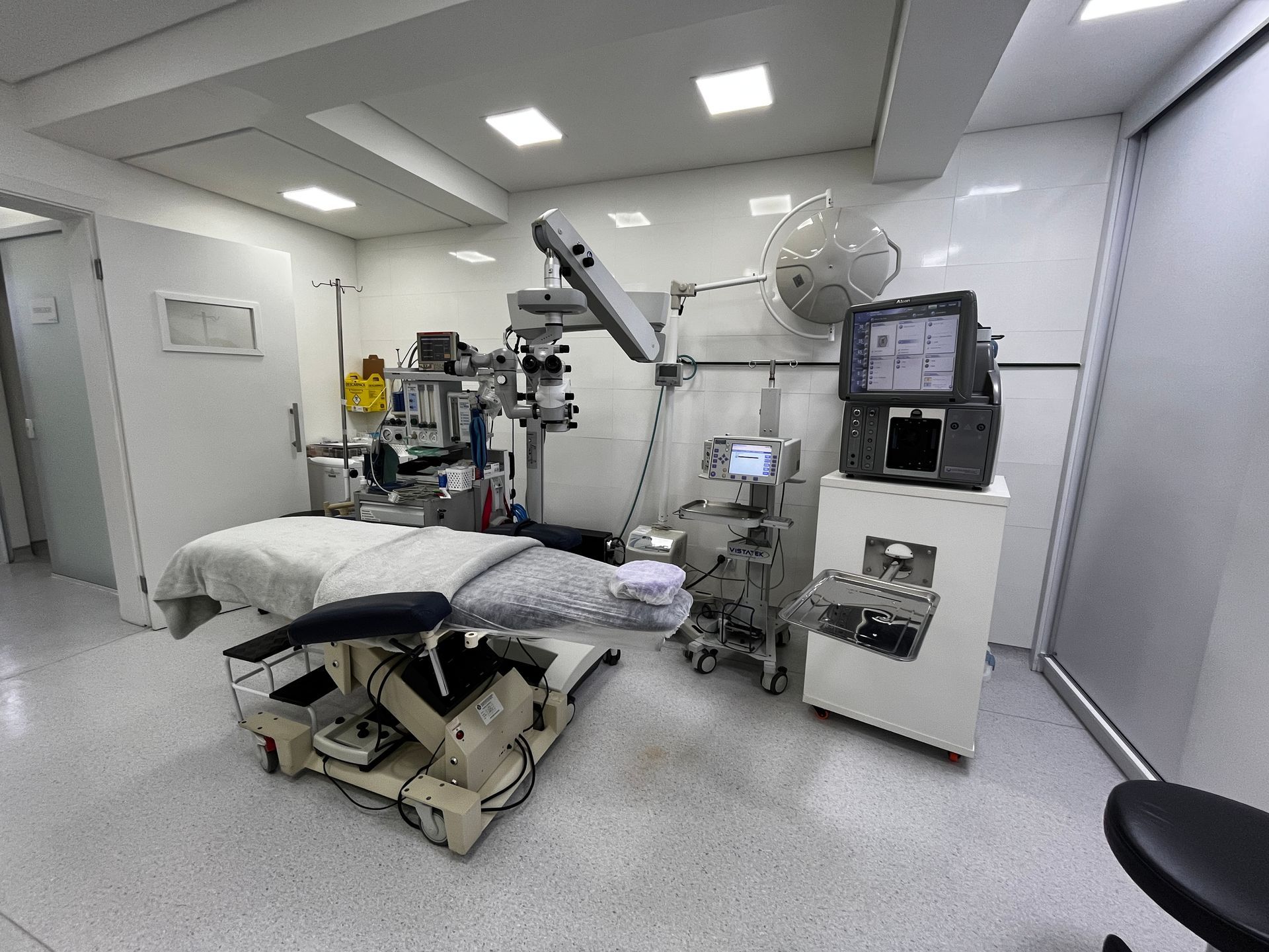 Uma sala de cirurgia com mesa cirúrgica, equipamentos médicos e iluminação adequada.