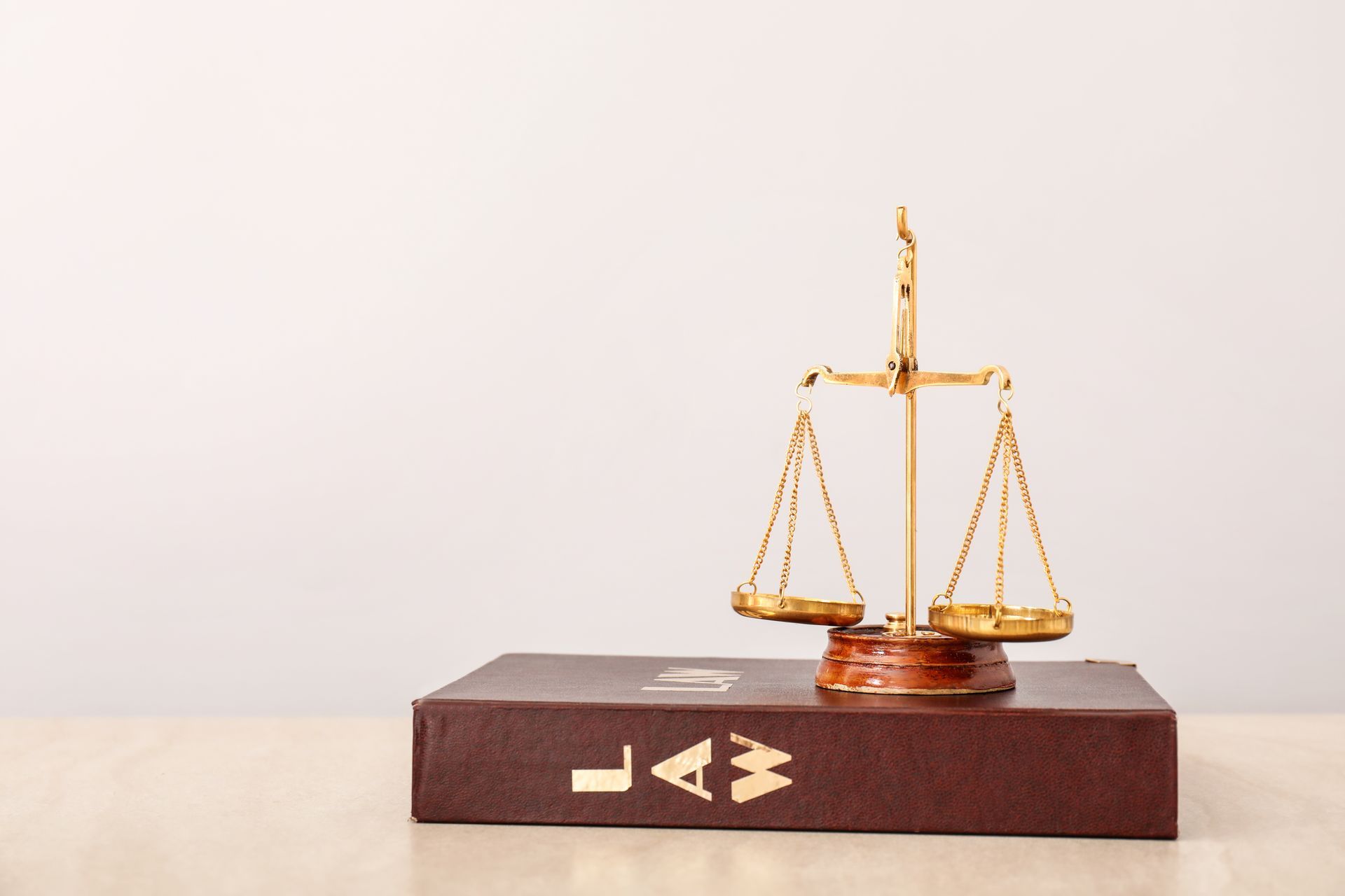 Gold scales of justice on a law book with 