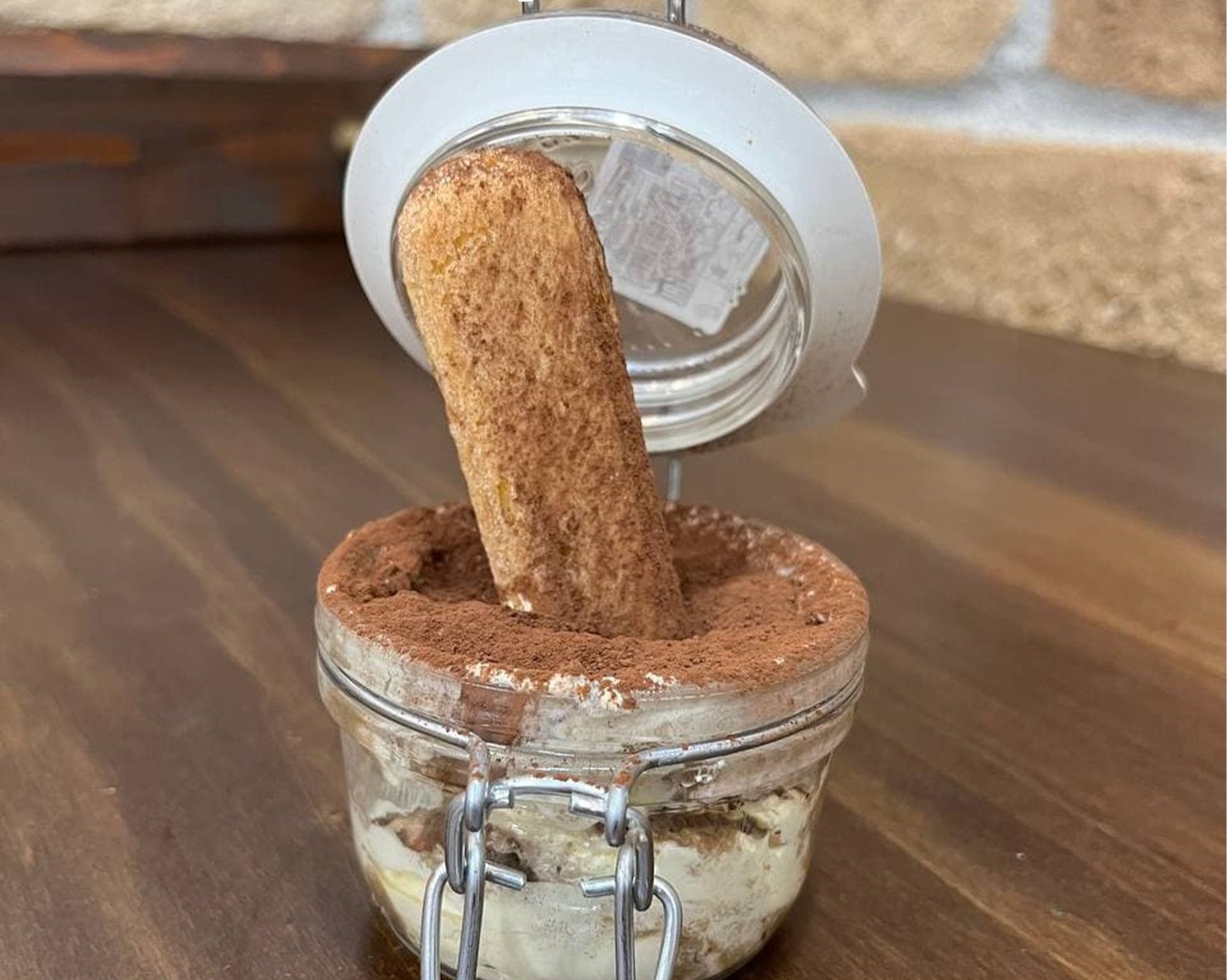 Un barattolo di cibo da cui spunta un biscotto.