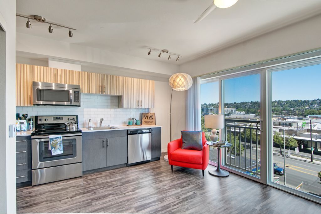 A kitchen with stainless steel appliances and a red chair
