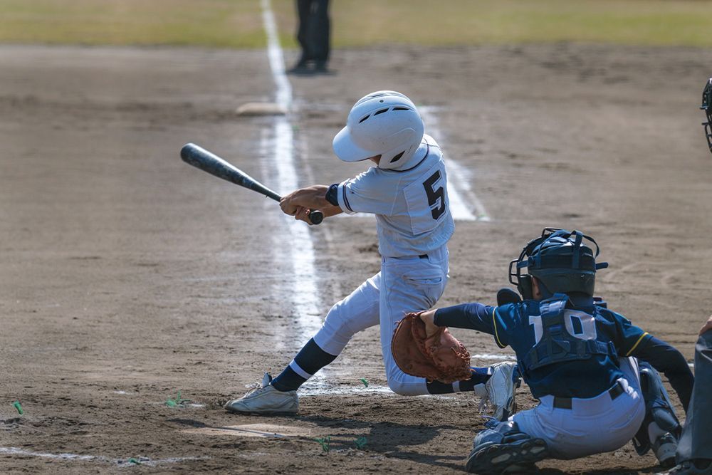 A young boy is swinging a baseball bat at a pitch.