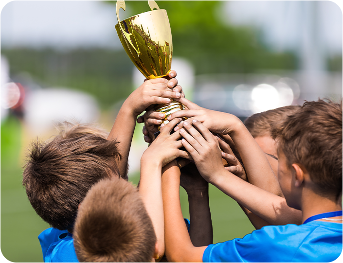 A group of young boys are holding a trophy in their hands.