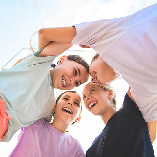 A group of people are standing in a circle and smiling