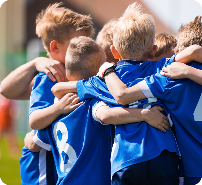 A group of young boys are hugging each other in a huddle.