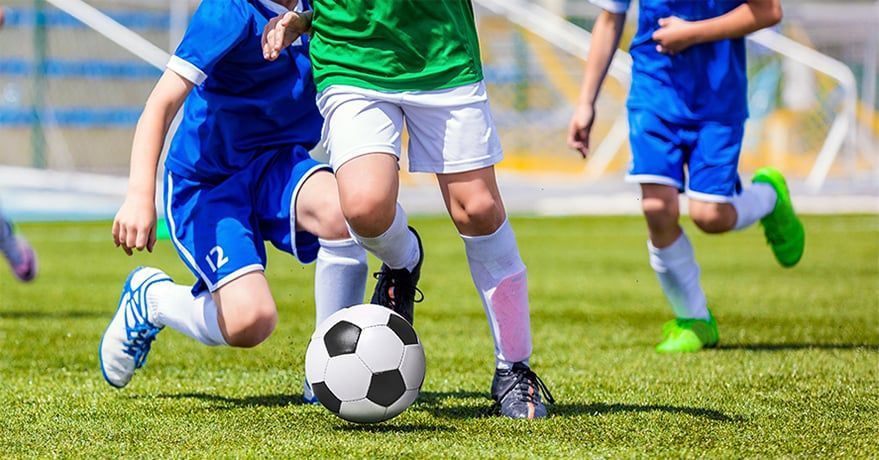 A group of young boys are playing soccer on a field.