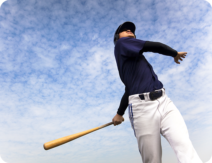 A baseball player is holding a bat and throwing it in the air