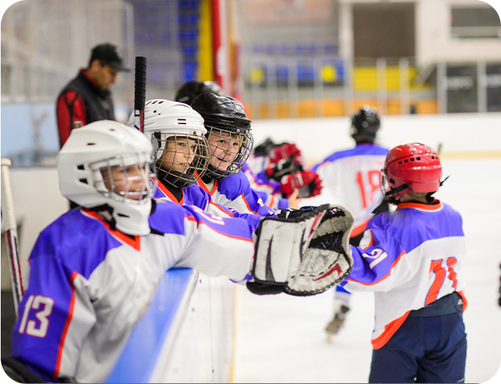 A group of young hockey players are huddled together on the ice.