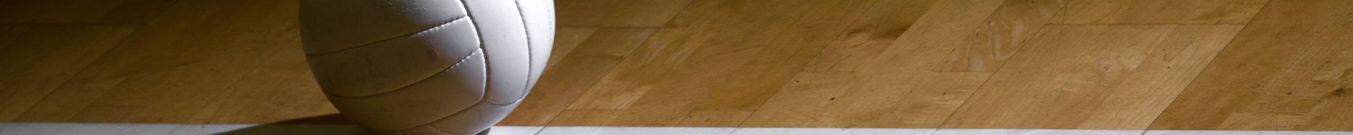 A white pole is standing in front of a wooden wall.