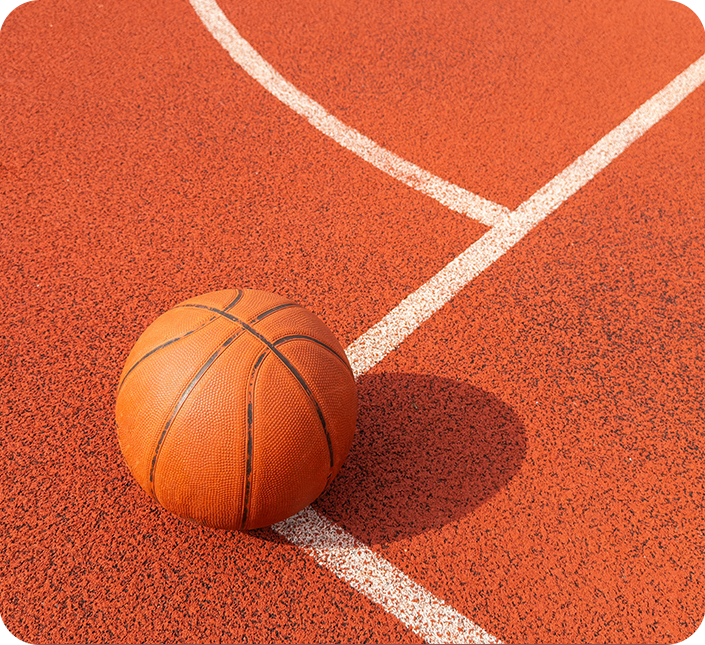 An orange basketball is sitting on a basketball court